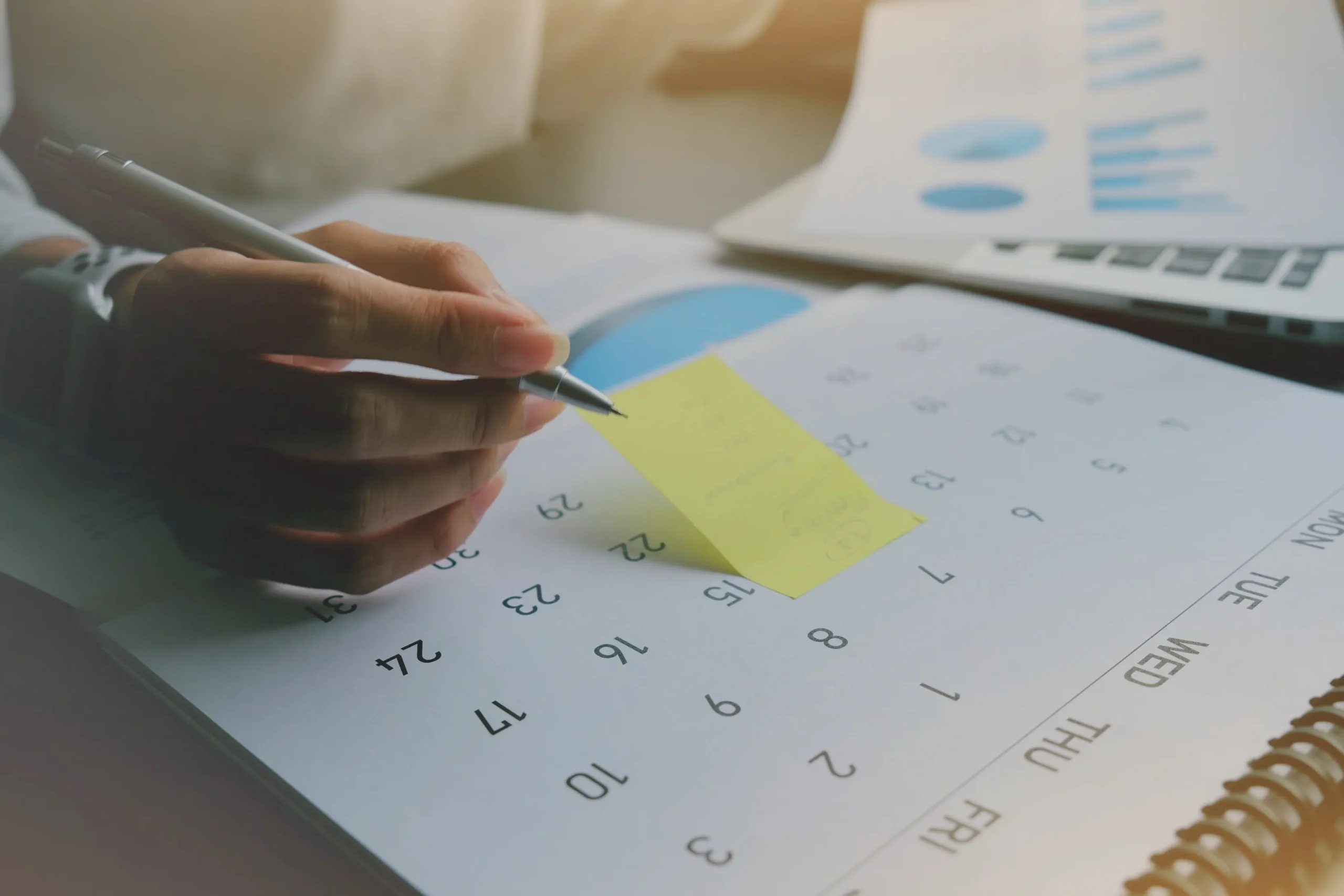 cropped hand woman sticking adhesive note calendar